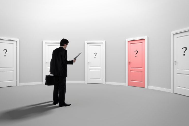 Options for decision-making or choosing the right path among multiple doors in a modern, minimalistic setting with one door highlighted in pink; image symbolizes choices and opportunities.