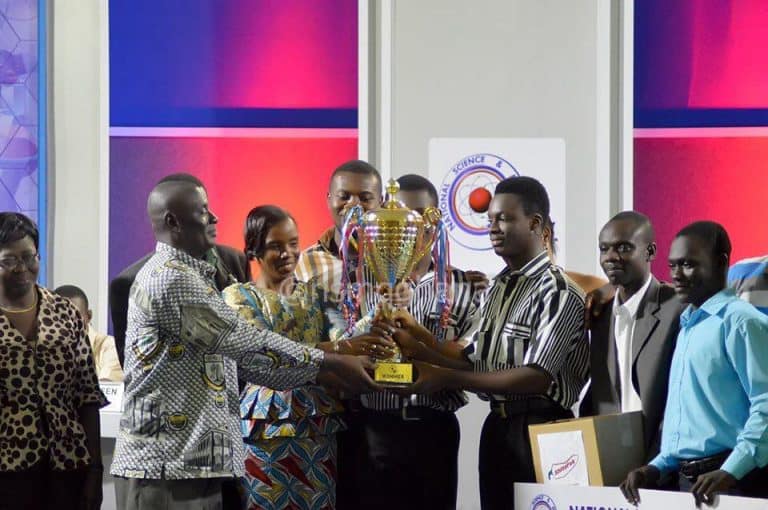 Winning team holding a trophy at a science competition event.