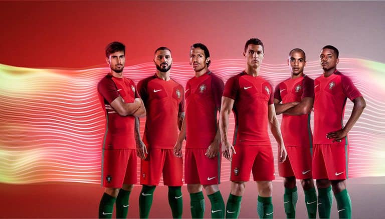 Portugal national football team athletes in red jerseys with green socks, standing together for promotional image.